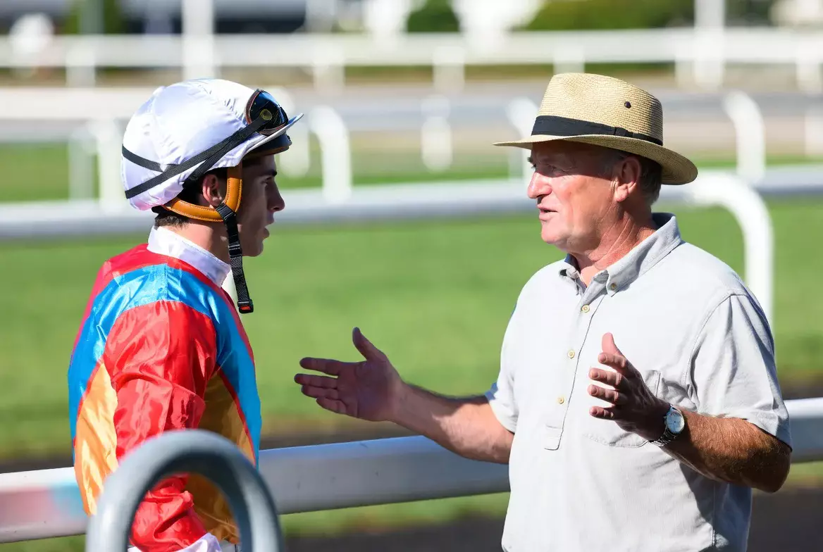 Jockey im Gespräch mit Trainer vor dem Rennen auf der Bahn